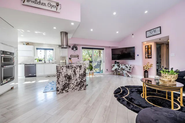 a living room with furniture a flat screen tv and a large window