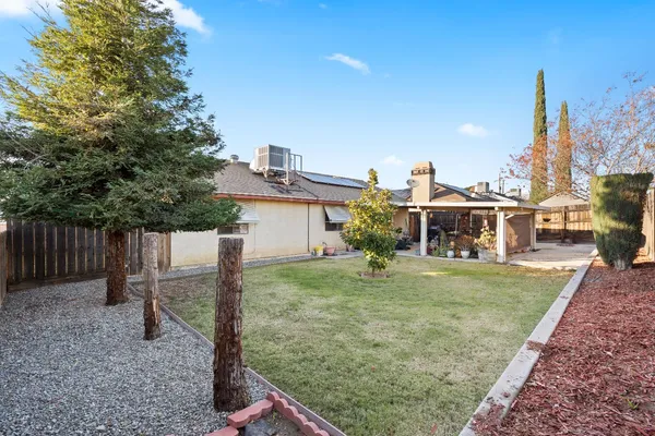 a view of a house with backyard and a tree