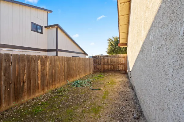 a view of a pathway of a building with wooden fence