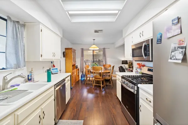 a kitchen with stainless steel appliances a stove sink microwave and cabinets
