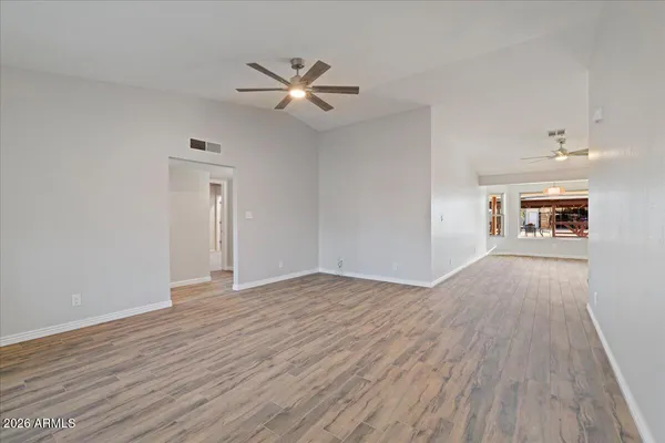 a view of empty room with wooden floor and window