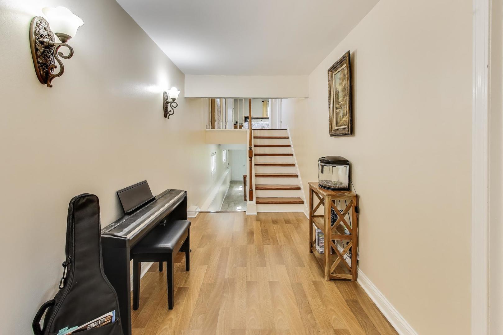 396 Stone Place Wheeling, IL 60090 - Photo 12 of 28 a view of a room with wooden floor windows and staircase