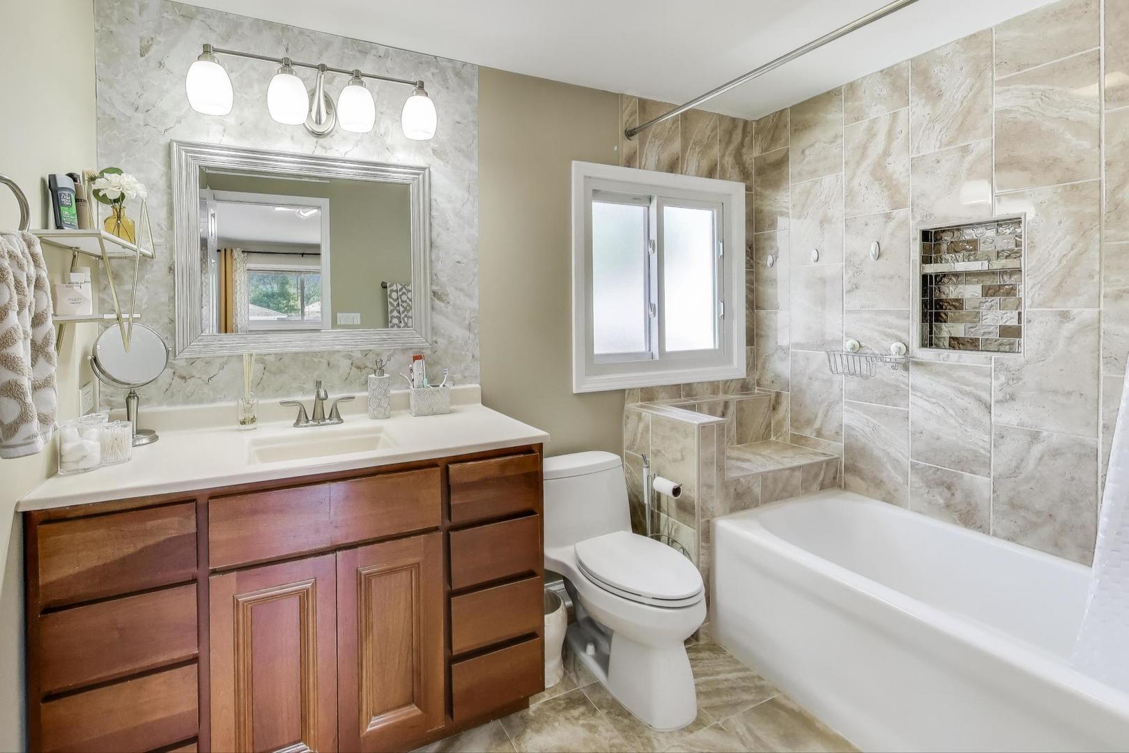 396 Stone Place Wheeling, IL 60090 - Photo 15 of 28 a bathroom with a sink toilet a mirror and bathtub
