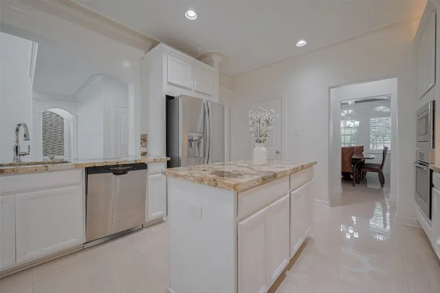 a kitchen with kitchen island granite countertop a stove and a sink