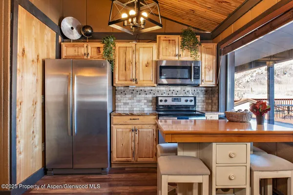 a kitchen with stainless steel appliances granite countertop a refrigerator a stove a sink and a microwave