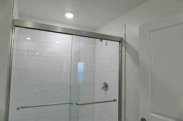 a bathroom with a shower and a glass door