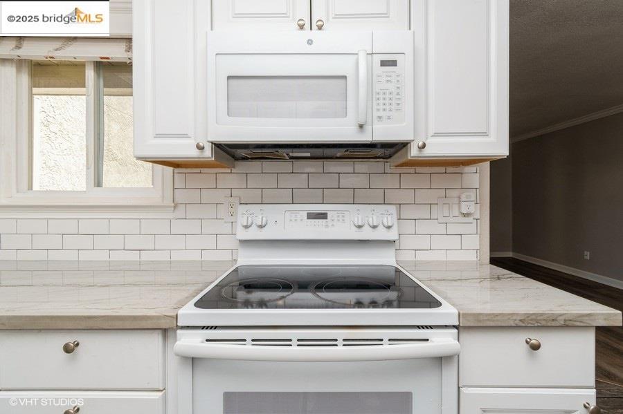 1505 Kirker Pass Road, Unit 170 Concord, CA 94521 - Photo 9 of 18 Kitchen with white appliances, tasteful backsplash, white cabinetry, and crown molding