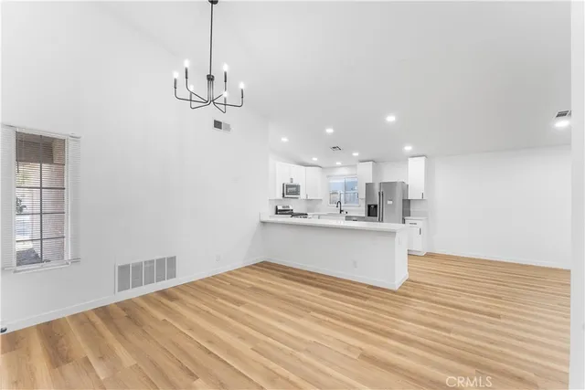 a view of a kitchen with wooden floor and a sink