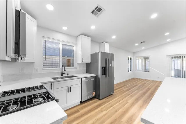 a kitchen with stainless steel appliances a refrigerator stove and sink