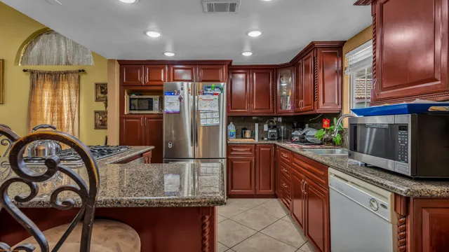 a kitchen with stainless steel appliances granite countertop a granite counter tops and a refrigerator