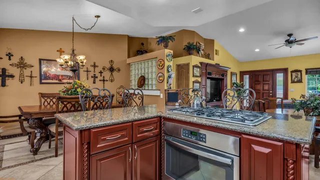 a kitchen area with granite countertop a table and chairs in it