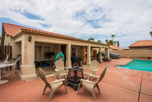a view of a patio with table and chairs near an umbrella