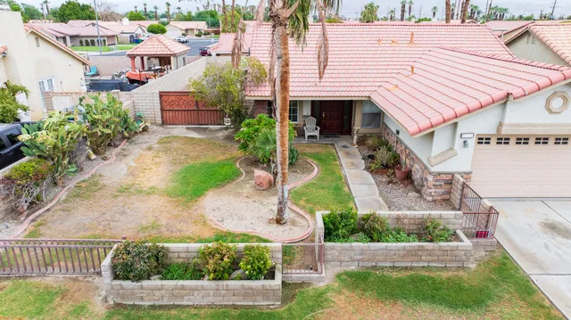 a aerial view of a house with a yard and potted plants