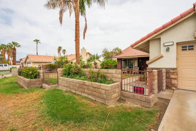 a view of a house with backyard and sitting area