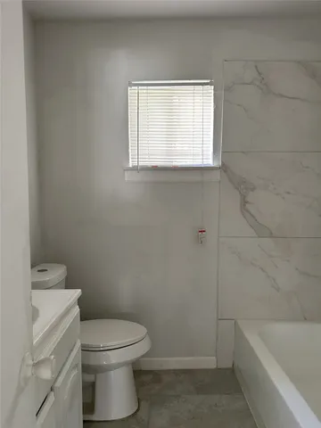 a bathroom with a toilet a sink and bathtub