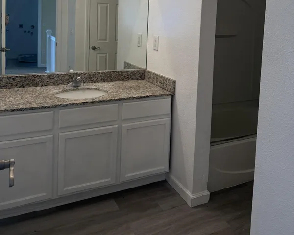 a bathroom with a granite countertop sink and vanity
