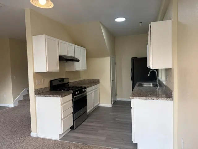 a kitchen with a sink a stove and a refrigerator