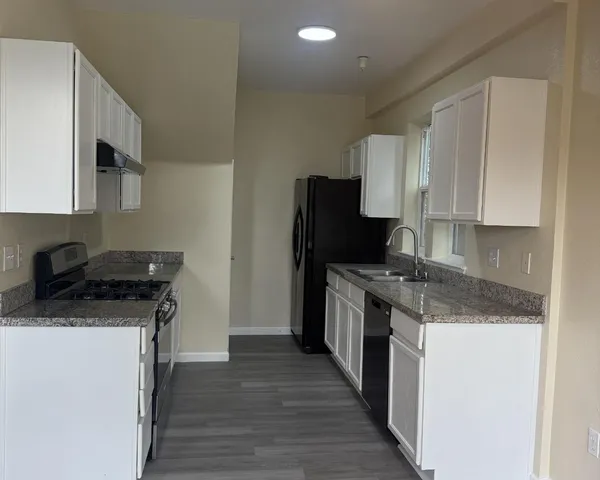 a kitchen with stainless steel appliances granite countertop a stove a sink and a refrigerator