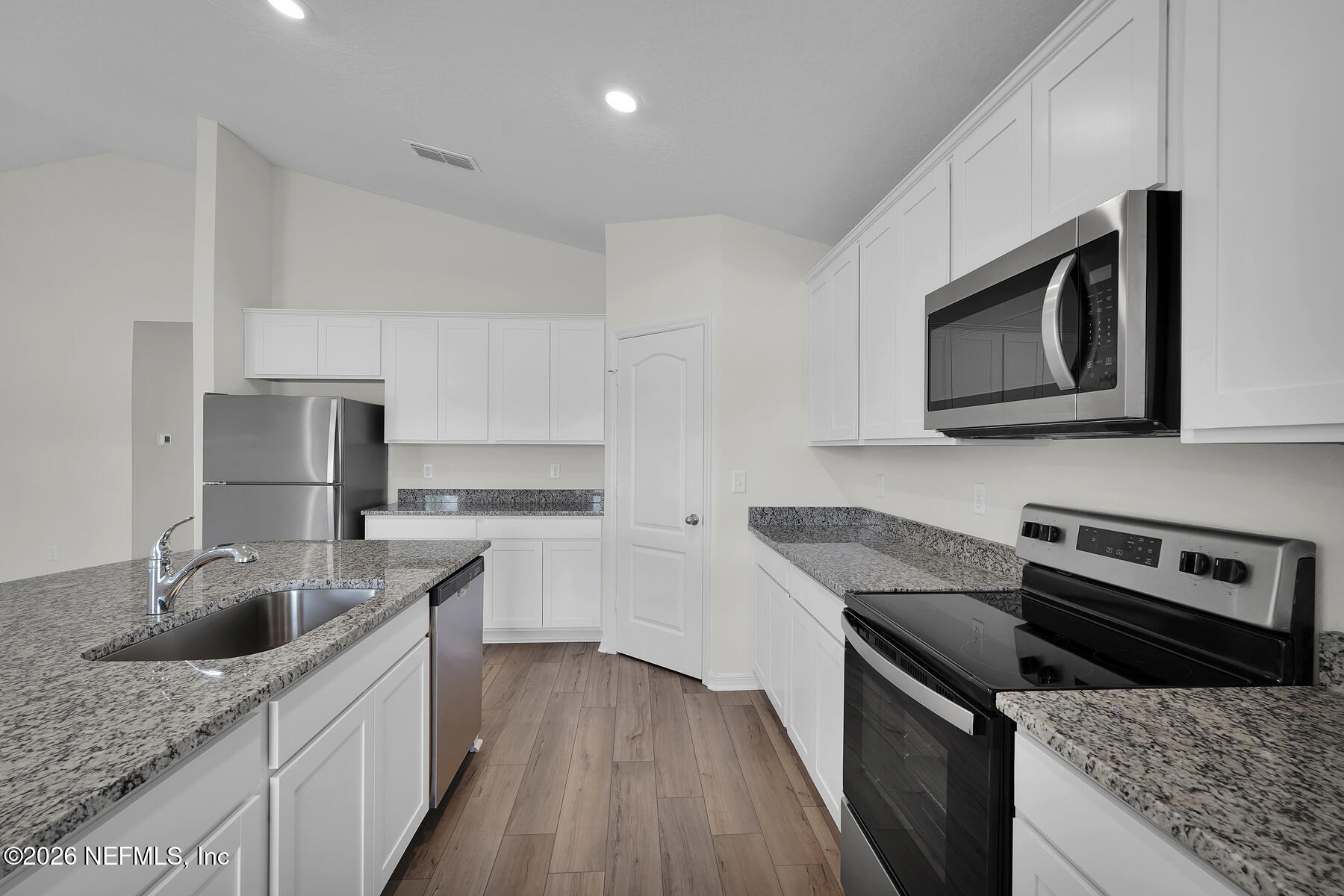 6949 Canoe Birch Road Jacksonville, FL 32219 - Photo 7 of 22 a kitchen with stainless steel appliances granite countertop a sink stove and microwave