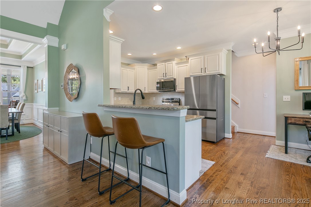 533 Falling Water Road Spring Lake, NC 28390 - Photo 14 of 50 a kitchen with stainless steel appliances granite countertop a dining table chairs refrigerator and microwave