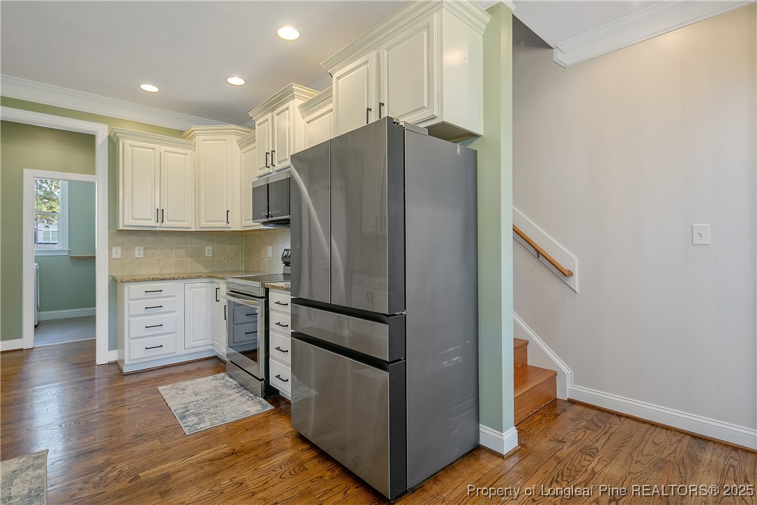 533 Falling Water Road Spring Lake, NC 28390 - Photo 17 of 50 a kitchen with granite countertop a refrigerator and a stove top oven