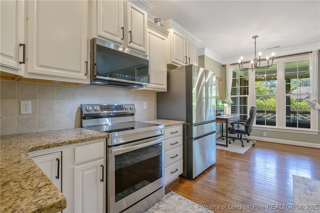 533 Falling Water Road Spring Lake, NC 28390 - Photo 20 of 50 a kitchen with stainless steel appliances granite countertop a stove a refrigerator and a microwave