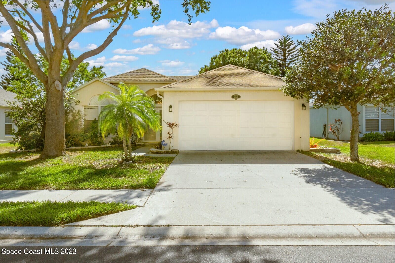a view of a white house with a yard and tree s