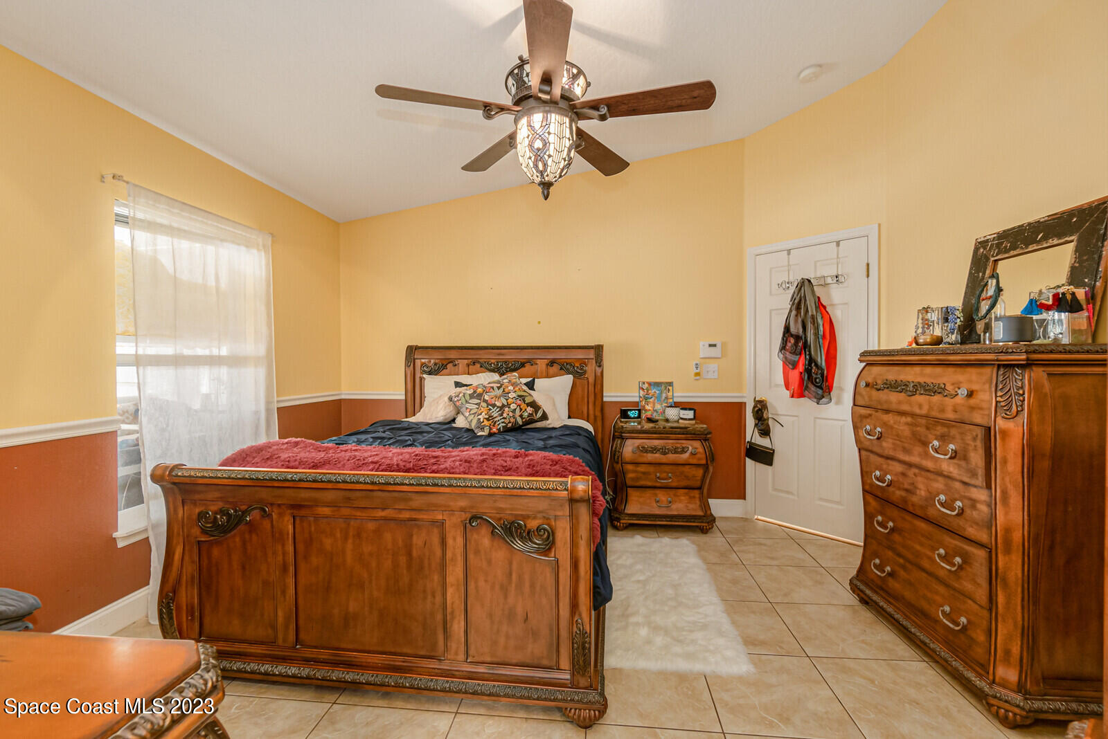 2154 Spring Creek Circle Palm Bay, FL 32905 - Photo 24 of 35 a bedroom with a bed and a chandelier