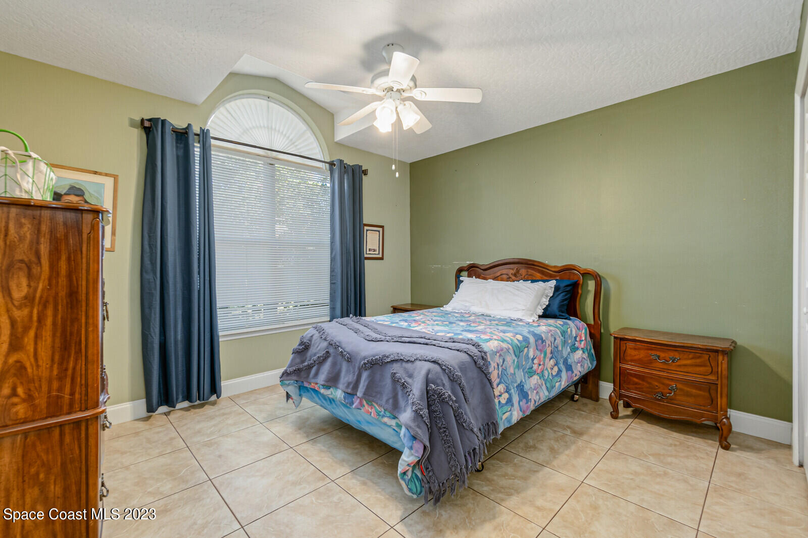 2154 Spring Creek Circle Palm Bay, FL 32905 - Photo 34 of 35 a spacious bedroom with a bed and a chandelier