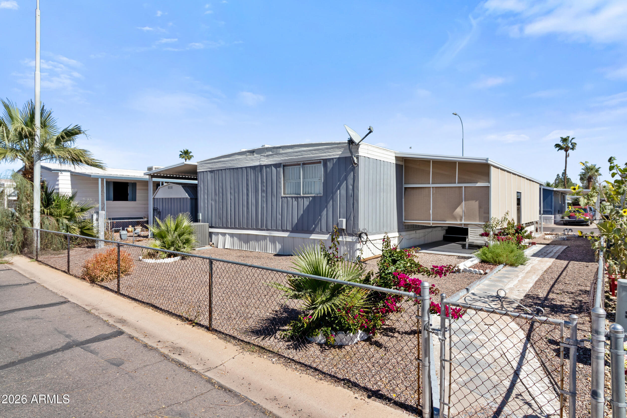 535 South Alma School Road, Unit 99 Mesa, AZ 85210 - Photo 39 of 77 a view of a patio with table and chairs potted plants and palm tree