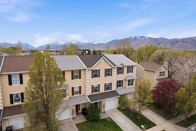 515 Inverness Lane, Unit 207 Heber City, UT 84032 - Photo 23 of 26 View of front facade featuring concrete driveway, stucco siding, a mountain view, a garage, and a shingled roof