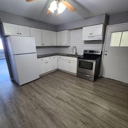 a kitchen with stainless steel appliances a refrigerator sink and cabinets