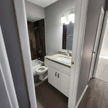 a bathroom with a granite countertop sink toilet and shower