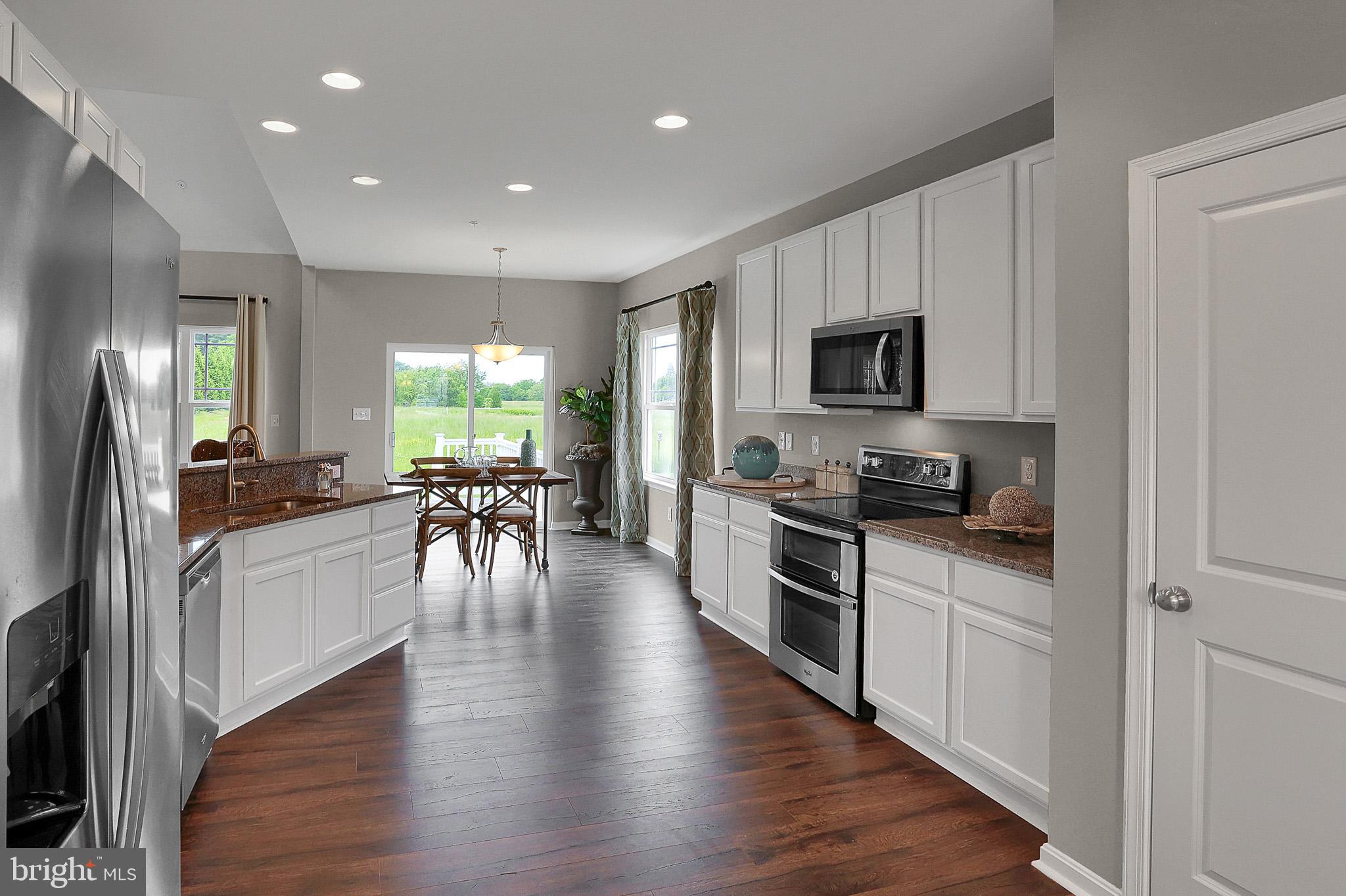 Tbd Tbd Tbd Pine Conowingo, MD 21918 - Photo 17 of 24 a kitchen with stainless steel appliances kitchen island granite countertop a stove top oven a sink a dining table and chairs with wooden floor