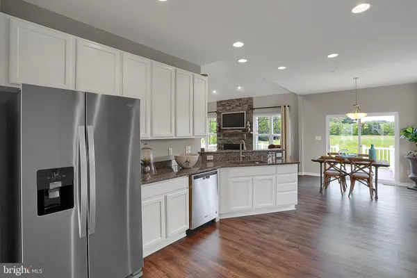 a kitchen with stainless steel appliances granite countertop a refrigerator stove microwave and sink