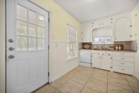 a kitchen with granite countertop white cabinets and white appliances