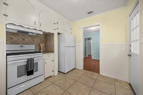 a view of a kitchen with refrigerator and cabinets