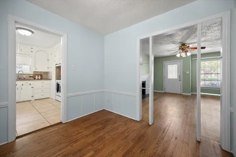 wooden floor in an empty room with a kitchen