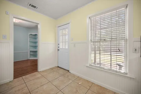 a view of an empty room with closet and a window