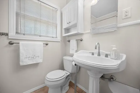 a bathroom with a sink a toilet and a window
