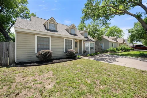a front view of house with yard and trees around
