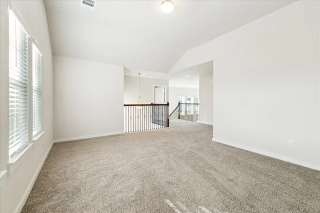 a view of empty room with wooden floor and window