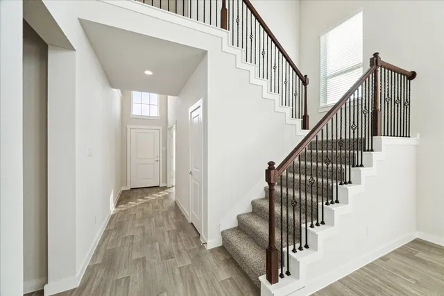 a view of staircase with wooden floor and white walls