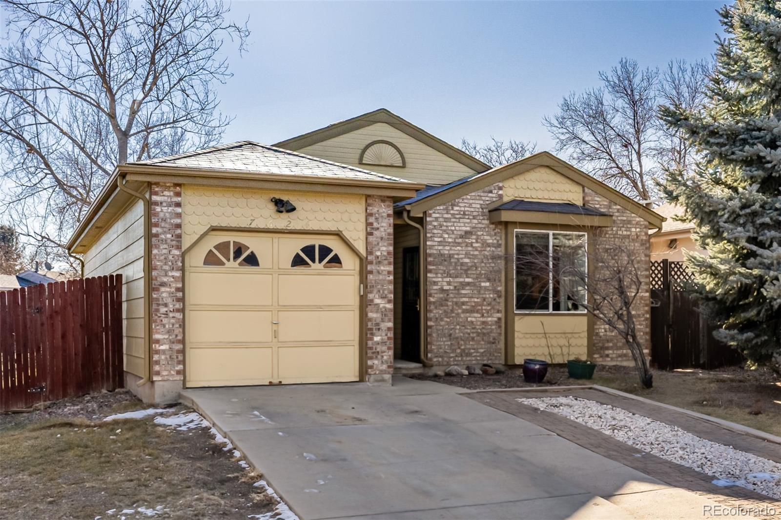 7624 Gray Way Arvada, CO 80003 - Photo 1 of 39 a front view of a house with a yard and garage
