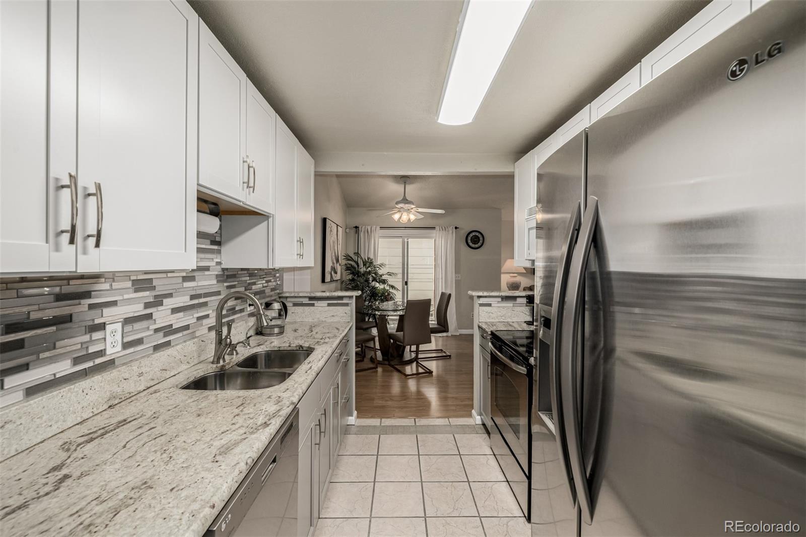 7624 Gray Way Arvada, CO 80003 - Photo 13 of 39 a kitchen with a sink a refrigerator and cabinets
