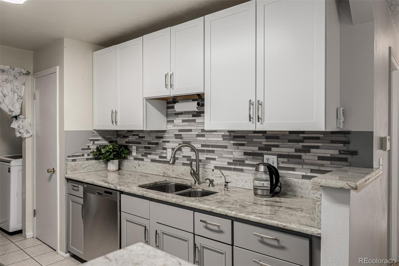 7624 Gray Way Arvada, CO 80003 - Photo 15 of 39 a kitchen with stainless steel appliances granite countertop a sink a stove and cabinets
