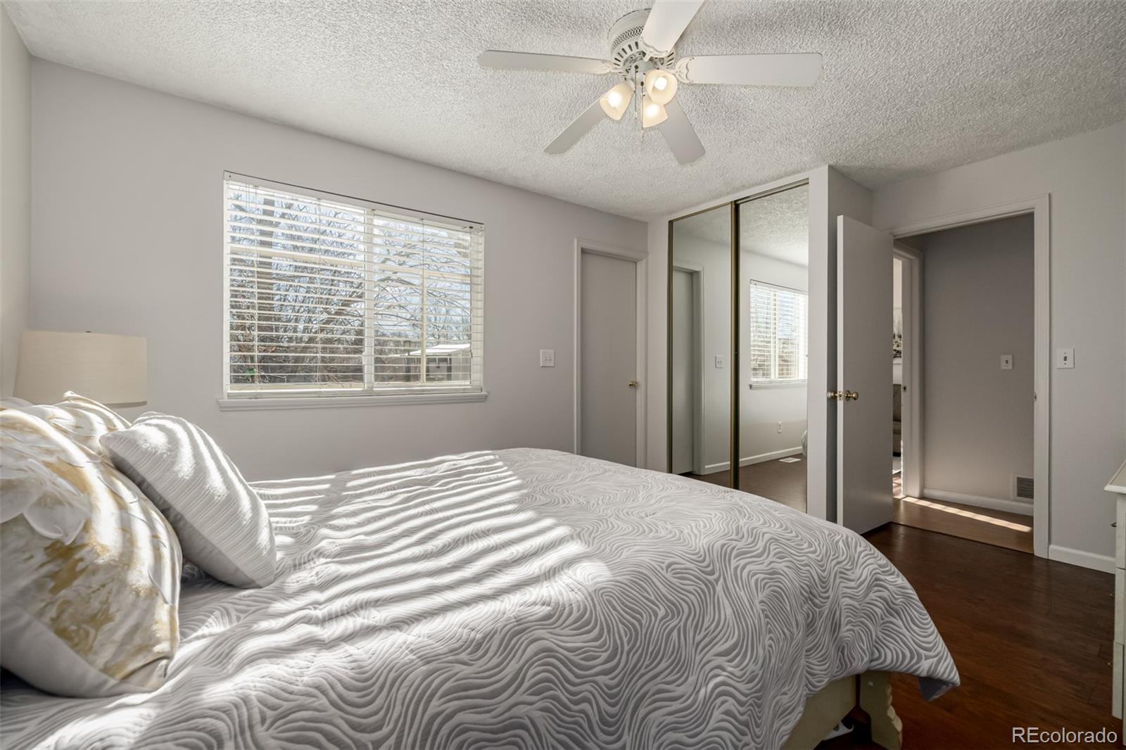 7624 Gray Way Arvada, CO 80003 - Photo 17 of 39 a bedroom with a large bed and a chandelier