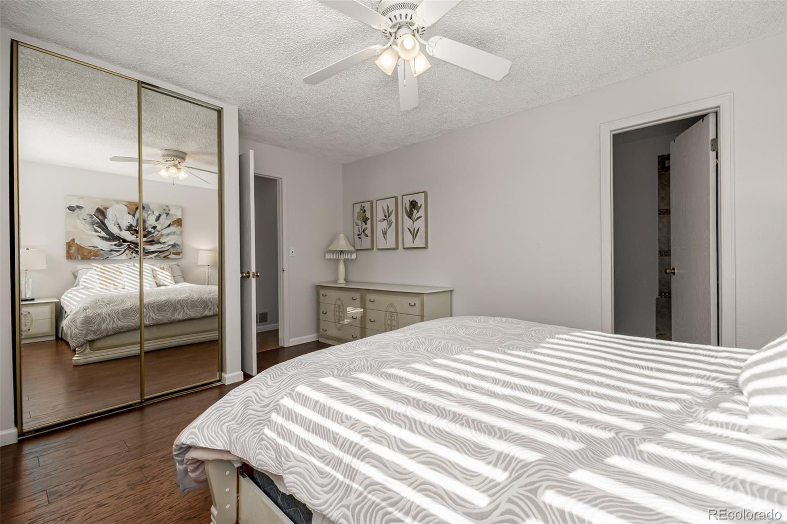 7624 Gray Way Arvada, CO 80003 - Photo 19 of 39 a bedroom with a bed and a chandelier