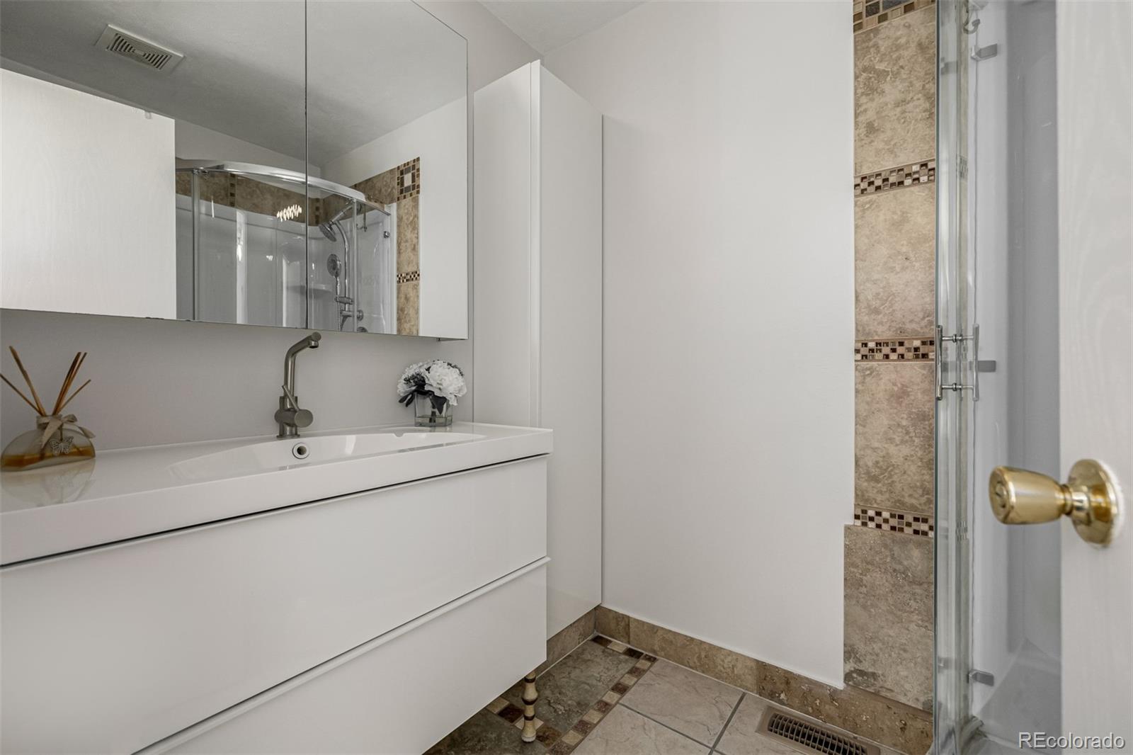 7624 Gray Way Arvada, CO 80003 - Photo 20 of 39 a bathroom with a sink and mirror