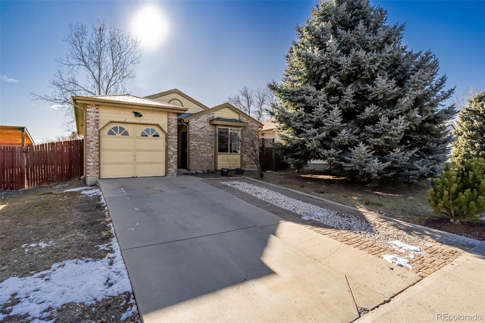 7624 Gray Way Arvada, CO 80003 - Photo 3 of 39 a front view of a house with a yard and garage